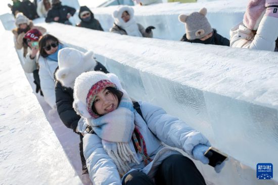 12月21日，游客在哈爾濱冰雪大世界園區(qū)游玩。新華社記者 張濤 攝